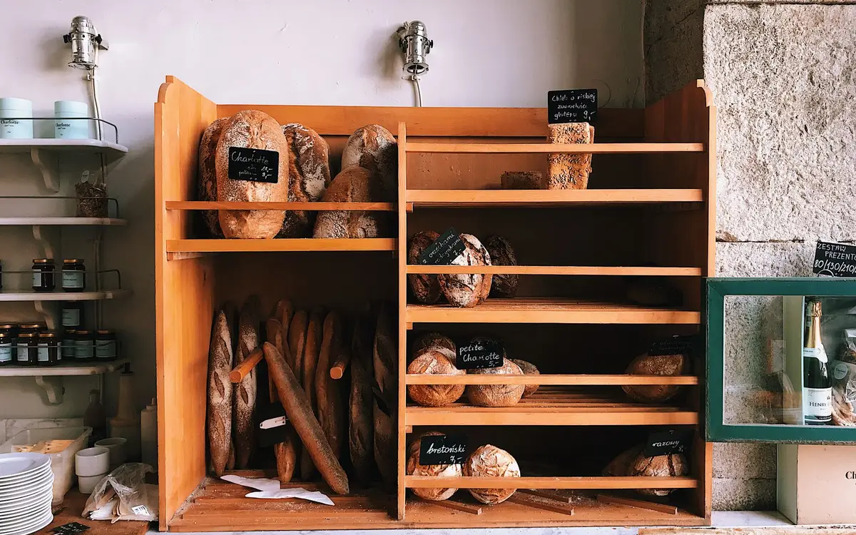 Loaves of fresh bread on wooden bakery shelves