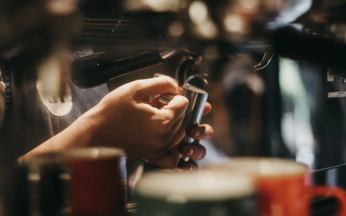 A barista pulling an espresso shot on a commercial espresso machine