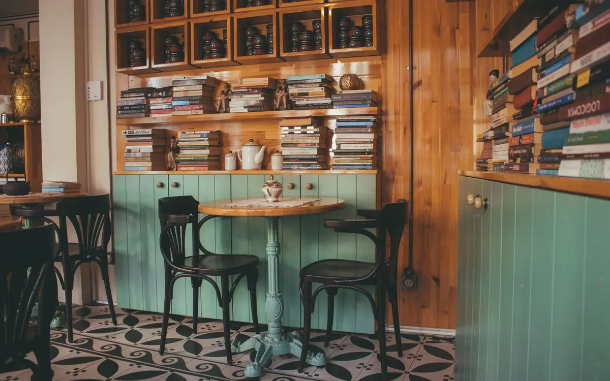 A cafe interior with wooden bookshelves and a reading nook