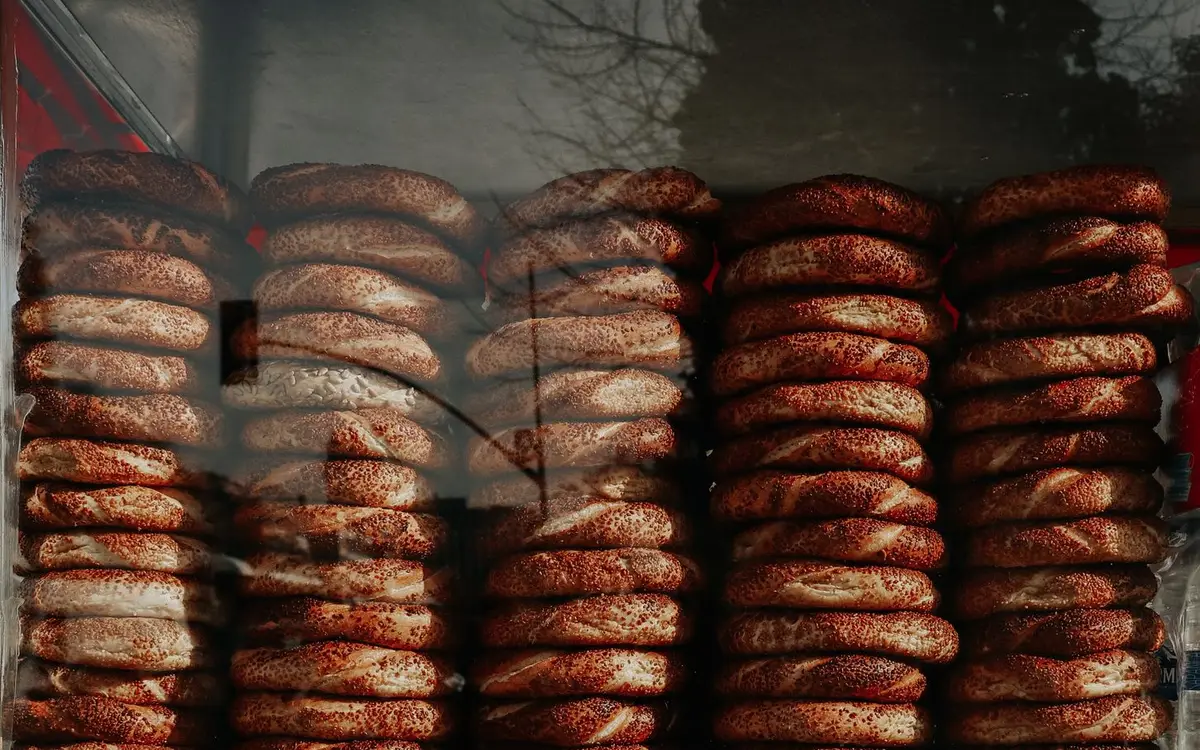 Stacks of fresh sesame bagels in a bakery window