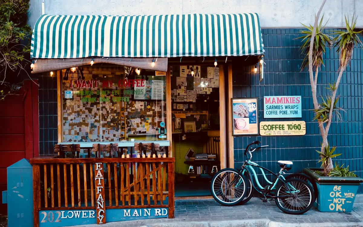 A small street cafe storefront with a striped awning